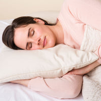 Woman on bed with ComfyCurve buckwheat pillow